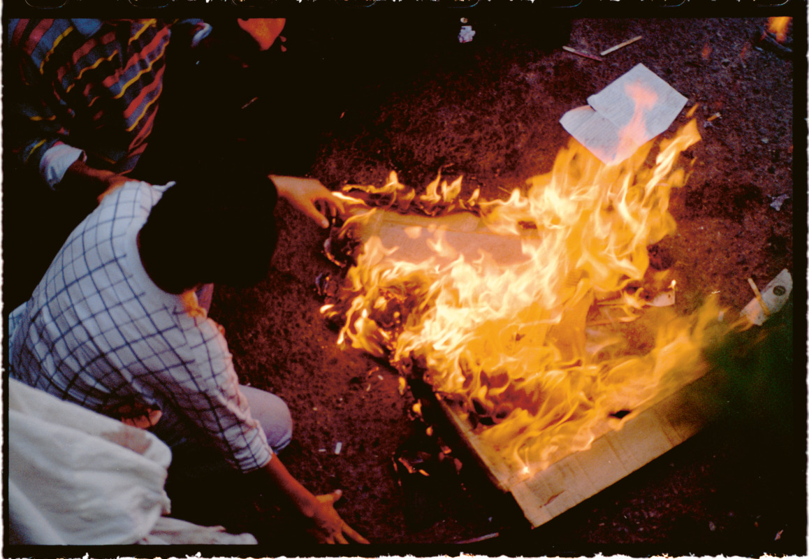 After riot police used tear gas, protesters burnt cardboard to use the smoketo drive the tear gas away. (Tehran, 1999) © Newsha Tavakolian